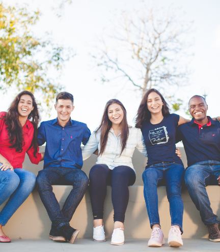 野外のベンチで写真を撮影する多国籍の仲間たち